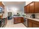 Functional kitchen featuring tiled floor, stainless steel appliances, and wood cabinets at 1922 Angel Fish Loop, Leesburg, FL 34748
