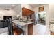 Open-concept kitchen featuring a kitchen island with seating, stainless steel appliances and wood cabinets at 1922 Angel Fish Loop, Leesburg, FL 34748