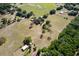 Aerial view of a property with lots of open land, trees, and outbuildings at 19726 Mccall Rd, Altoona, FL 32702