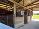 Interior of the barn features multiple stalls with metal grate doors for livestock and ample ventilation at 19726 Mccall Rd, Altoona, FL 32702