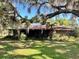 An older single-story home with mature trees and moss, showcasing its natural setting at 19726 Mccall Rd, Altoona, FL 32702