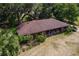 Aerial of a single-story brick house with a dark brown roof, lush trees, and a well-maintained yard at 19726 Mccall Rd, Altoona, FL 32702