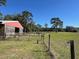A green pasture with fence line, barn, and scenic trees, perfect for livestock grazing at 19726 Mccall Rd, Altoona, FL 32702