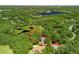 Aerial view of property in a lush community with large lake, mature trees and beautiful surroundings at 2010 Otters Pond Rd, Fruitland Park, FL 34731