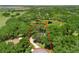 Aerial view highlighting property lines, wooded area, and pond, showcasing the home's unique natural setting at 2010 Otters Pond Rd, Fruitland Park, FL 34731