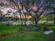 Beautiful backyard with a small seating area under the trees, overlooking a serene pond with water lilies at 2010 Otters Pond Rd, Fruitland Park, FL 34731
