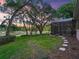 Serene backyard with mature trees, lush lawn, screened-in patio, and scenic pond views at 2010 Otters Pond Rd, Fruitland Park, FL 34731