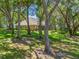 View of the backyard with mature trees, patio, and screened-in porch, perfect for outdoor entertaining and relaxation at 2010 Otters Pond Rd, Fruitland Park, FL 34731