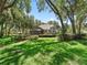 Manicured backyard with screened in lanai, outdoor seating and lush landscaping on a sunny day at 2010 Otters Pond Rd, Fruitland Park, FL 34731