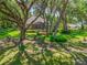 Expansive backyard with screened-in porch, mature trees, and lush lawn, offering serene outdoor living at 2010 Otters Pond Rd, Fruitland Park, FL 34731