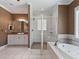 Bathroom features tile flooring, soaking tub, glass shower, and vanity area at 2010 Otters Pond Rd, Fruitland Park, FL 34731