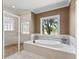 Bathroom with tile flooring, soaking tub, and shower with glass block window at 2010 Otters Pond Rd, Fruitland Park, FL 34731