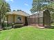 Exterior view of the home showcasing the screened-in lanai, manicured lawn, and mature landscaping at 2010 Otters Pond Rd, Fruitland Park, FL 34731
