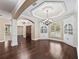 Elegant living room boasts rich hardwood floors, custom built-ins, and tray ceiling detail at 2010 Otters Pond Rd, Fruitland Park, FL 34731