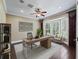 Stylish office with bay windows, modern desk, ceiling fan, and elegant decor at 2010 Otters Pond Rd, Fruitland Park, FL 34731