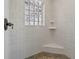 Tiled shower featuring a glass block window, corner seat, and tiled floor at 2010 Otters Pond Rd, Fruitland Park, FL 34731