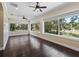Empty sunroom features hardwood flooring and many windows overlooking backyard at 2010 Otters Pond Rd, Fruitland Park, FL 34731