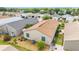 An aerial view shows a well-manicured backyard with a patio area and lush landscaping at 2095 Thornton Ter, The Villages, FL 32162