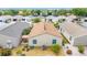 An aerial view shows a well-manicured backyard with a patio area and lush landscaping at 2095 Thornton Ter, The Villages, FL 32162