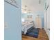 Inviting bedroom with light blue walls, wood floors, and beach-inspired artwork at 2095 Thornton Ter, The Villages, FL 32162