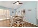 Charming dining room with a wood-look floor, blue walls, and comfortable seating features lots of natural light at 2095 Thornton Ter, The Villages, FL 32162