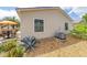 Tan home exterior featuring tidy landscaping, and an orange umbrella patio set at 2095 Thornton Ter, The Villages, FL 32162