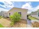 Tan home exterior featuring tidy landscaping with bushes and a rock ground covering at 2095 Thornton Ter, The Villages, FL 32162