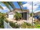 Charming home featuring a white garage door, flowering shrubs, and a screened-in lanai at 2095 Thornton Ter, The Villages, FL 32162