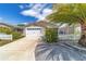 Attractive home featuring a two-car garage, well-manicured landscaping, and sidewalk at 2095 Thornton Ter, The Villages, FL 32162