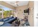 Cozy lanai offers a relaxing space with comfortable seating, a ceiling fan, and views of the lush outdoor landscape at 2095 Thornton Ter, The Villages, FL 32162