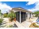 A home with a screened-in porch and mature landscaping with flowers in bloom at 2095 Thornton Ter, The Villages, FL 32162