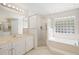 This bathroom has tile floors, dual vanities, a large shower and a soaking tub with a glass block window at 2420 Sr 471, Sumterville, FL 33585