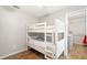 This bedroom has a bunk bed, closet with built-ins, and wood floors at 2420 Sr 471, Sumterville, FL 33585