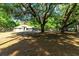 Spacious property with mature trees, a well-maintained lawn, and charming exterior features create an inviting atmosphere at 2420 Sr 471, Sumterville, FL 33585