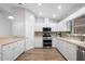 Bright kitchen with white cabinets, stainless steel appliances, and wood-look flooring at 2420 Sr 471, Sumterville, FL 33585