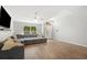 Bright living room with wood-look tile floors, a ceiling fan, and a large window offering views of the outdoors at 2420 Sr 471, Sumterville, FL 33585