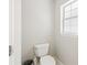 This toilet room features a toilet, a small window and white walls at 2420 Sr 471, Sumterville, FL 33585