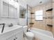 Clean bathroom with a white vanity, toilet, and shower with built-in shelves at 25519 Colmar Ave, Sorrento, FL 32776