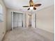 Bedroom featuring neutral carpet, a closet with shelves, and a ceiling fan at 25519 Colmar Ave, Sorrento, FL 32776