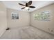 Cozy bedroom with carpet, two windows with natural light, and a ceiling fan at 25519 Colmar Ave, Sorrento, FL 32776