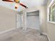 Bright bedroom showcasing carpet flooring, a closet with shelves, and ample natural light at 25519 Colmar Ave, Sorrento, FL 32776