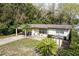 A lovely single story home with a carport and mature trees, seen from an aerial perspective at 25519 Colmar Ave, Sorrento, FL 32776