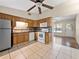 Well-equipped kitchen with oak cabinets, tiled floors, and an opening to the living area at 25519 Colmar Ave, Sorrento, FL 32776