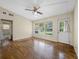Inviting living room with a view of the backyard through large windows and a ceiling fan at 25519 Colmar Ave, Sorrento, FL 32776