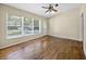 Bright living room featuring hardwood floors, ceiling fan, and large windows for natural light at 25519 Colmar Ave, Sorrento, FL 32776
