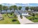 Aerial view of a beautiful lakeside home with lush landscaping and a private dock for boating enthusiasts at 26516 Savage Cir, Howey In The Hills, FL 34737