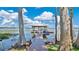 A wooden dock leads to a covered boat lift on a serene lake, framed by lush trees at 26516 Savage Cir, Howey In The Hills, FL 34737