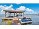 Dock featuring boat and jet ski lifts, creating the ultimate lakeside retreat at 26516 Savage Cir, Howey In The Hills, FL 34737