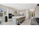 Modern, open kitchen with an island, barstool seating, and stainless steel appliances at 26516 Savage Cir, Howey In The Hills, FL 34737