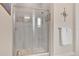 Shower with neutral tile, glass enclosure, and mosaic tile base at 26516 Savage Cir, Howey In The Hills, FL 34737